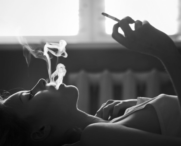 Yatakta sigara içen kadın