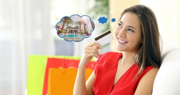 Elinde kredi kartı ile tatil düşünen bir kadın